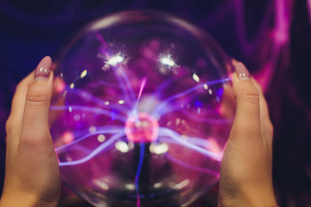 istock Hand touching a plasma ball with smooth magenta-blue flames. 1179436081