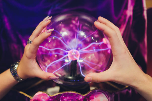 istock Hand touching a plasma ball with smooth magenta-blue flames. 1179436093
