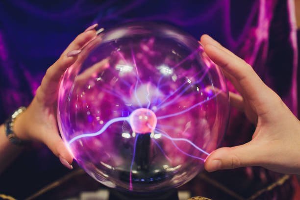 istock Hand touching a plasma ball with smooth magenta-blue flames. 1179436102