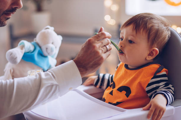 istock Father Entertain baby to eat 1179436971