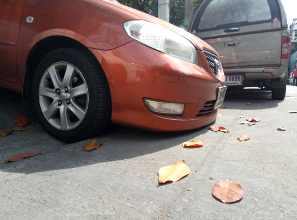 carro estacionado com um afastamento muito baixo, o amortecedor dianteiro encontra-se na terra - fine motor skills - fotografias e filmes do acervo