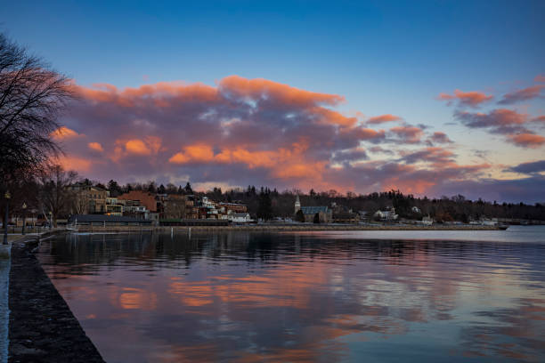 Clouds form over Skaneateles Lake, Skaneateles, a popular vacation destination in the Finger Lakes Region of New York State, USA, before sunset on a winter day. stock photo