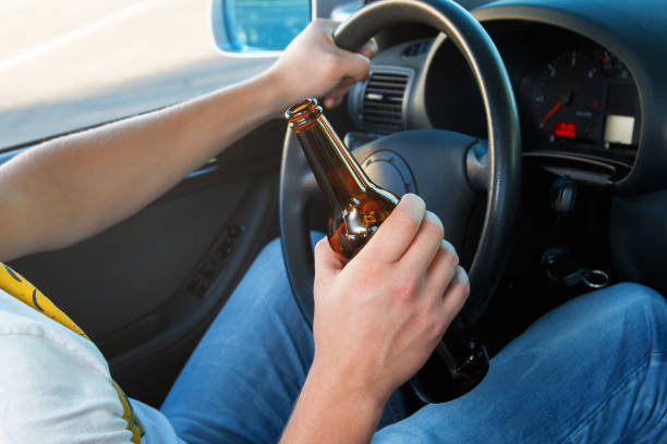 istock Car driver holding a bottle of beer 1179444613