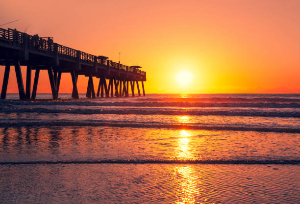 istock Sun rising over horizon and pier in Florida. 1179445600