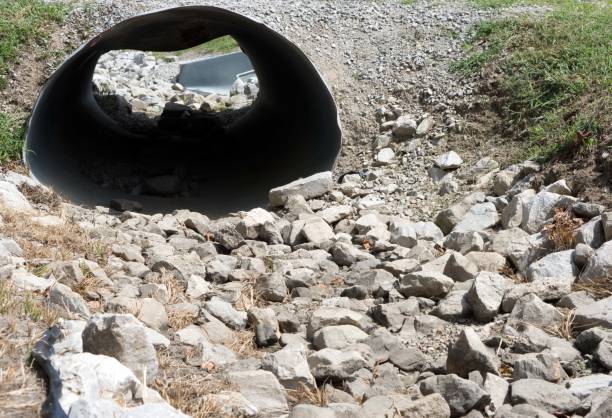 White stones and a misshaped culvert under a road. A white stone path leading through a culvert under a road. misshaped stock pictures, royalty-free photos & images