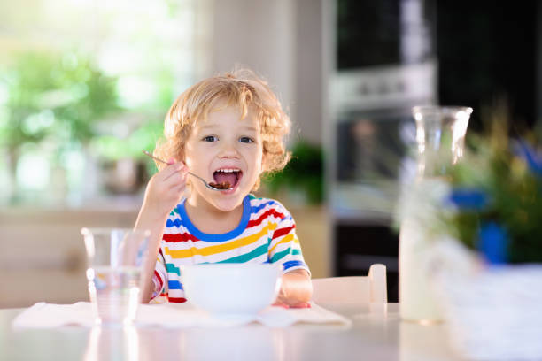 istock Child eating breakfast. Kid with milk and cereal. 1179448850