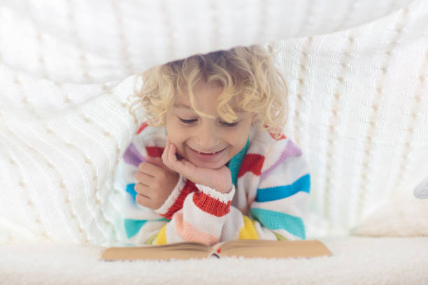 istock Child reading book in bed. Kids read books. 1179449123