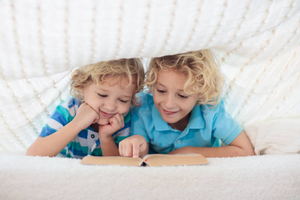 istock Child reading book in bed. Kids read books. 1179449157