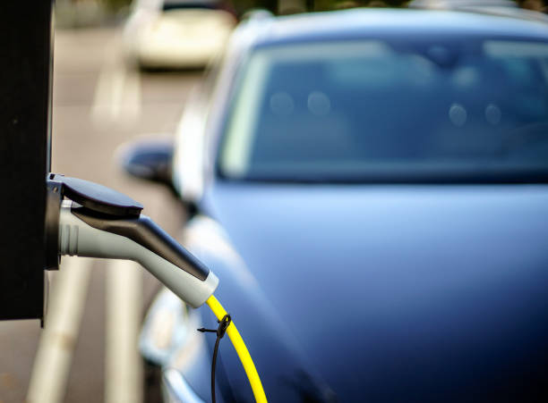 istock Electric Vehicle is changing in street. 1179450442