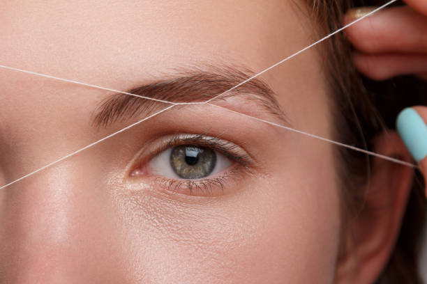 Eyebrow correction with a white thread stock photo