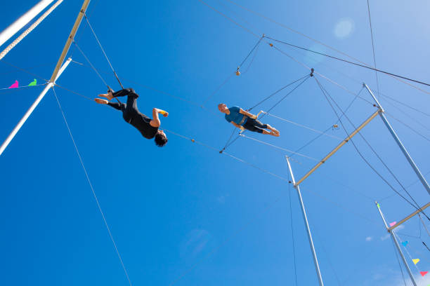 istock Trapeze artists flying in the blue sky 1179462059