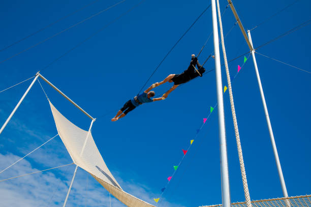 istock Two trapeze artists flying in the blue sky 1179462074