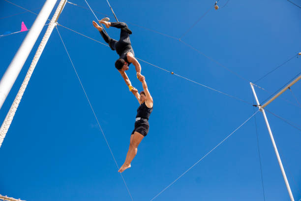 istock Trapeze artists swinging together in the sky 1179462096