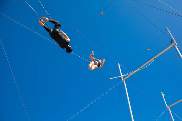 istock Trapeze artists flying in the blue sky 1179462113