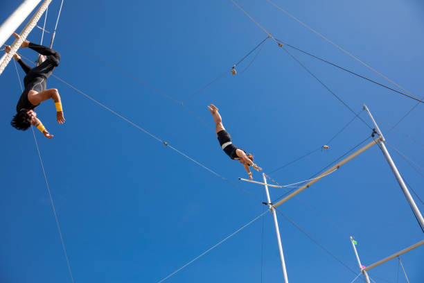 istock Trapeze artists flying in the blue sky 1179462124