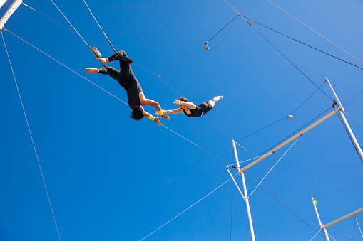 Trapecistas volando en el cielo azul photo
