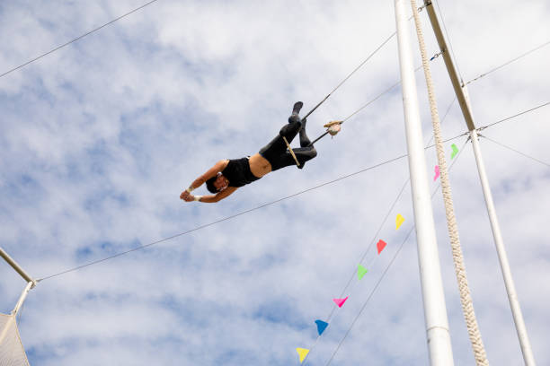istock Trapeze artist hanging on swing with legs 1179462159