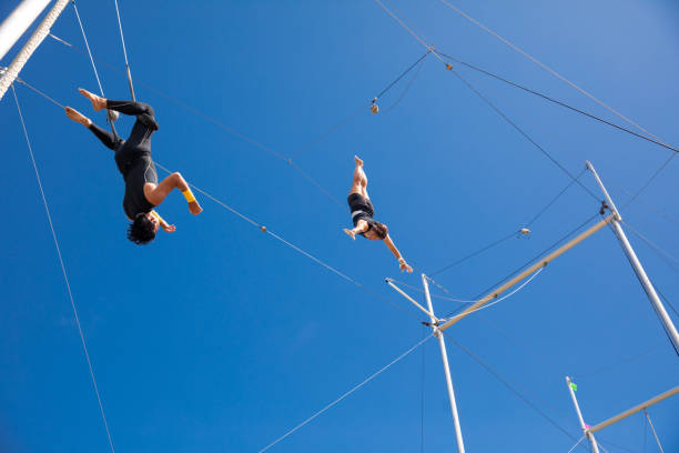 istock Trapeze artists flying in the blue sky 1179462165