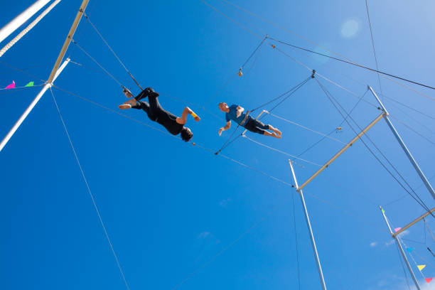 istock Two trapeze artists flying in the blue sky 1179462179