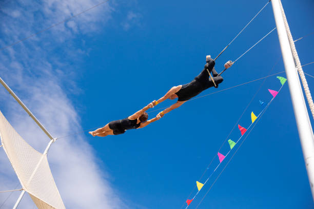 Trapeze artists swinging together in the sky stock photo