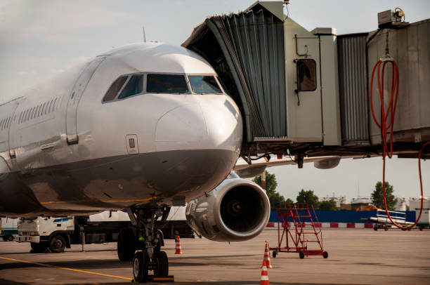 航空機に接続されたテレトラップ。望遠鏡のはしごは航空機に接続されています。空港エンジニアリングシステムは動作します。飛行機から乗客を降りる。スリーブは航空機に接続されてい� - 3681 ストックフォトと画像