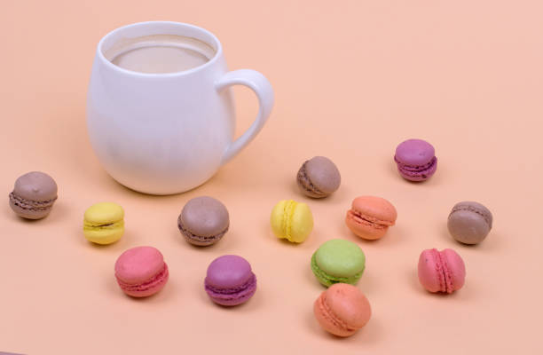 istock White Cup of fragrant cappuccino with macarons cakes on orange background 1179463595