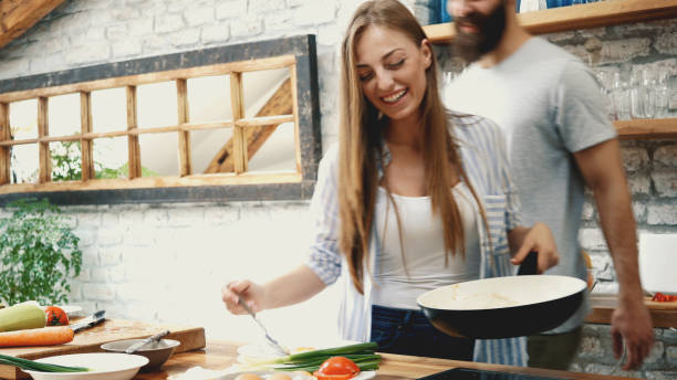 istock Young couple making dinner together at home 1179467490