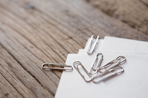 Selective focus of Many paper clips and papers on the wood background and copy space