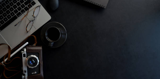 istock Top view of dark modern photographer workspace with camera, laptop computer with copy space 1179480752