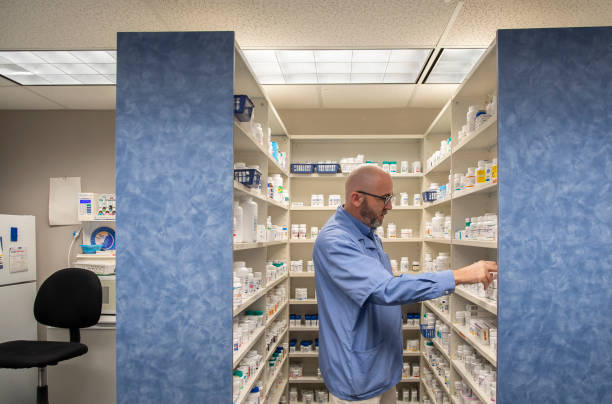 Pharmacist picking medicines off a shelf stock photo