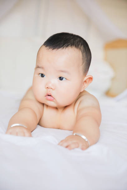 Asian baby lying on bed