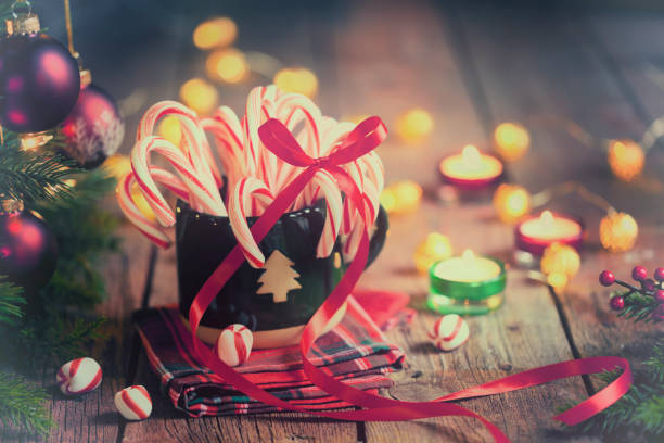 Candy canes, candles and bright Christmas lights background