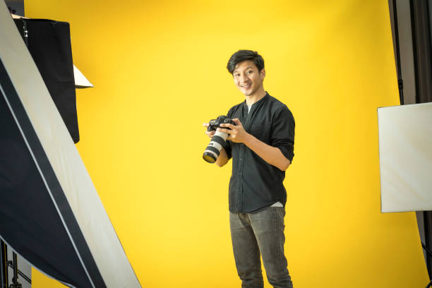 istock Young  Professional photographer with camera in on photo studio background. 1179494004
