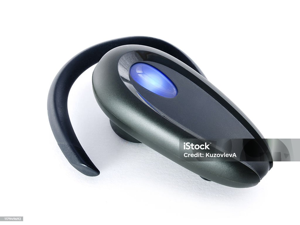 Black Bluetooth hands free ear device with blue button Black hands-free isolated on white background Audio Equipment Stock Photo