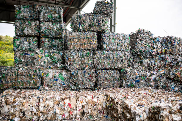 Bales of Compressed Recyclable Materials Stacked Outdoors Close-up of compressed paper and plastic gathered into bundles and stacked outdoors at waste management facility. recyclable materials stock pictures, royalty-free photos & images