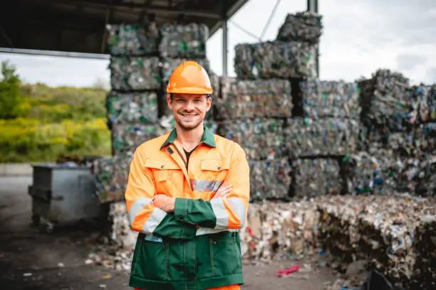 Photo of Smiling Workman Outdoors at Waste Management Facility