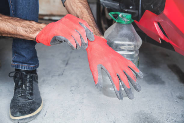 istock Man wearing red protective gloves in garage. 1179509040