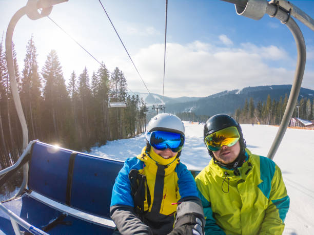 coppia che si fa selfie con l'attrezzatura da sci mentre si solleva fino alla collina. attività sportiva invernale - taking selfie in glass elevator foto e immagini stock