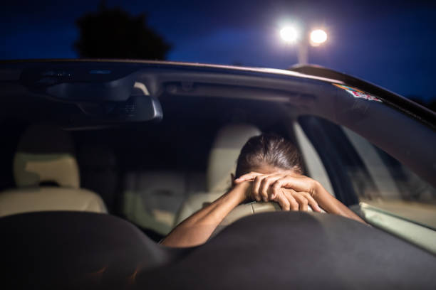 giovane donna alla volante della sua auto, super stanca - driving text messaging accident danger foto e immagini stock