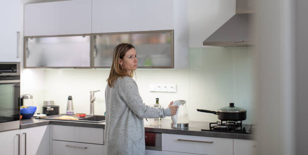 istock Pretty, young woman in her modern bright kitchen 1179513063