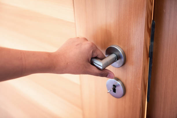 woman hand tiene la manopola della porta mentre apre una porta in camera da letto, blocca il sistema di sicurezza e la sicurezza di accesso della porta., interior design di doorknob che entra nella stanza privata di accessibilità - wooden door foto e immagini stock