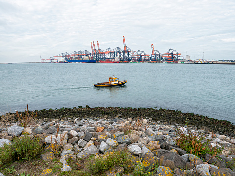 Belfast, Northern Ireland, United Kingdom - October 11, 2020: Bulk container ship at a commercial dock with silo at Belfast Harbour.  In the background is Cave Hill.