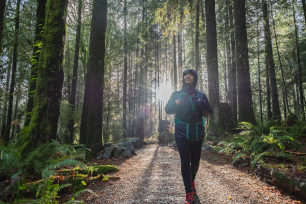 istock Rainy Forest Hike, Young Woman with Backpack Enjoying Forest Walk 1179516311