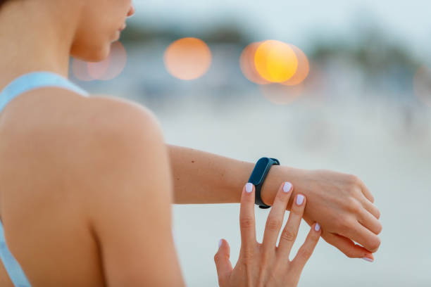 Checking the fitness tracker on her wrist Female jogger checking the fitness tracker on her wrist pedometer photos stock pictures, royalty-free photos & images