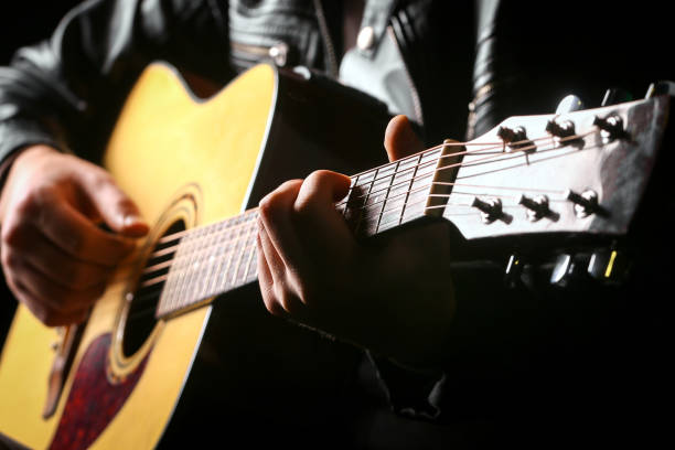 istock Young men playing the guitar with black background 1179516618