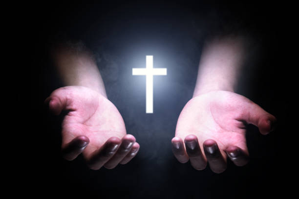 istock Human hands praying to god with shiny Christian Cross 1179519323