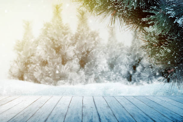 istock Wooden table with snowy fir trees 1179519525