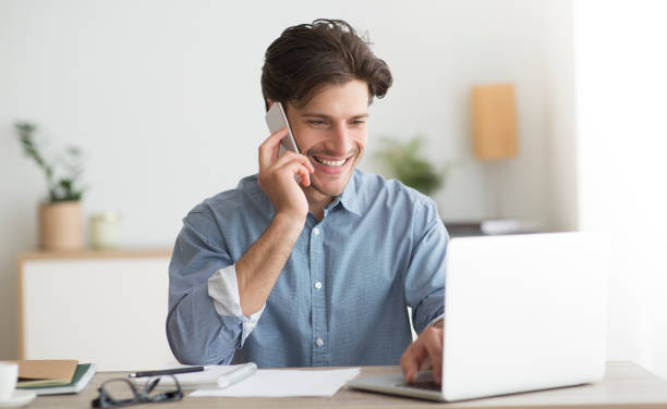 istock Happy Entrepreneur Talking On Cellphone Sitting At Laptop In Office 1179519624
