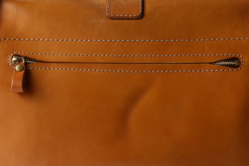 Close-up of brown leather bag texture background.