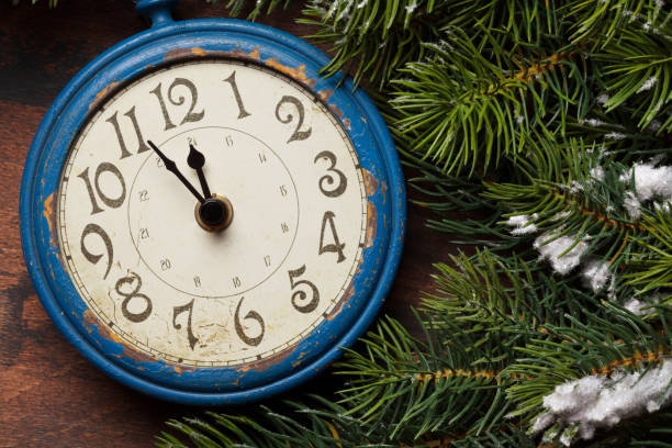 istock Christmas fir tree and alarm clock over old wood 1179520563